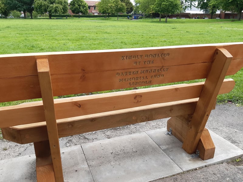 The inscription on the back of the bench reads: 'Kindly donated by the Darren Munnelly Memorial Fund Lincoln'.