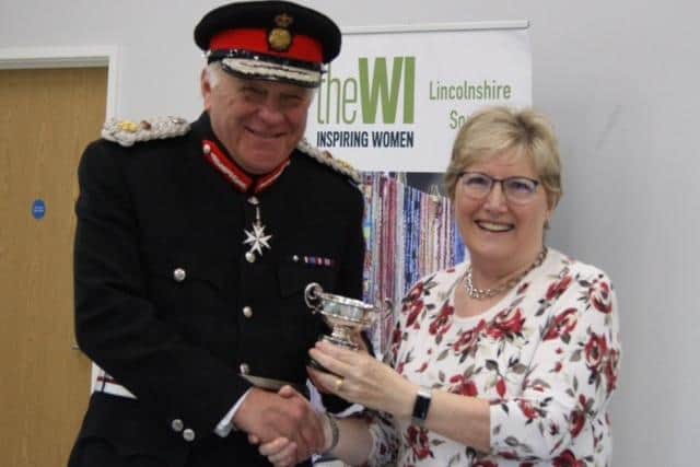 Elizabeth Mantle, President of Ropsley WI, receiving the Cynthia Pearson trophy from Lord Lieutenant of Lincolnshire, Toby Dennis. Photo: Janis Tunaley