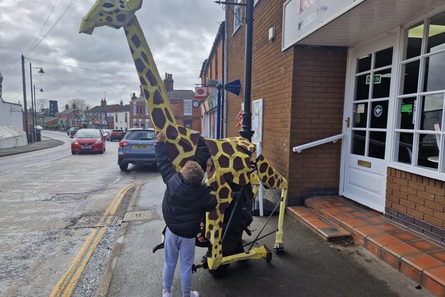 A young boy   signs his name on  Zarafa before   Sebastian Mayer and his life-size giraffe puppet set off to Skegness from Burgh le Marsh.