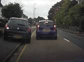 A still from Operation Snap footage showing a car driving up a footpath attempting to undertake another vehicle.