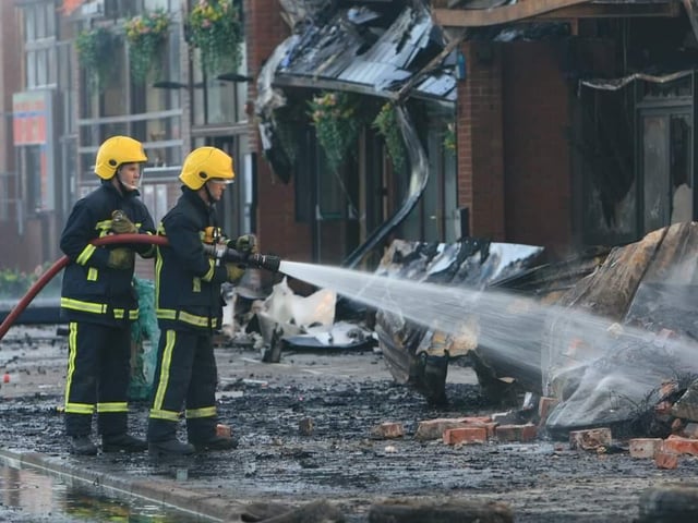 The aftermath - firefighters were still damping down the rubble at 9.30am the next morning.