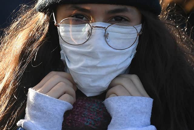 A woman wears a protective face mask in London. (Photo: Getty).
