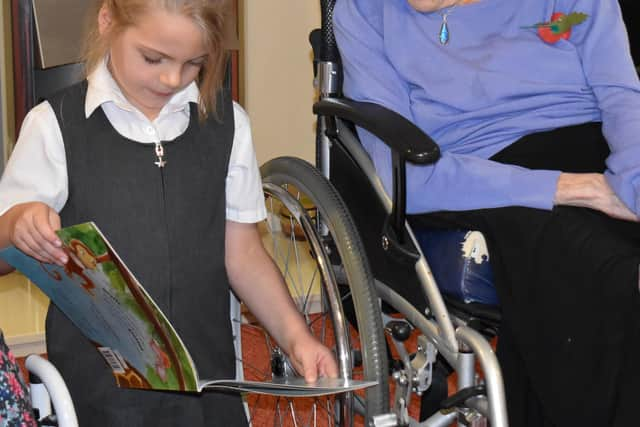 Another resident enjoys a story from a youngster.