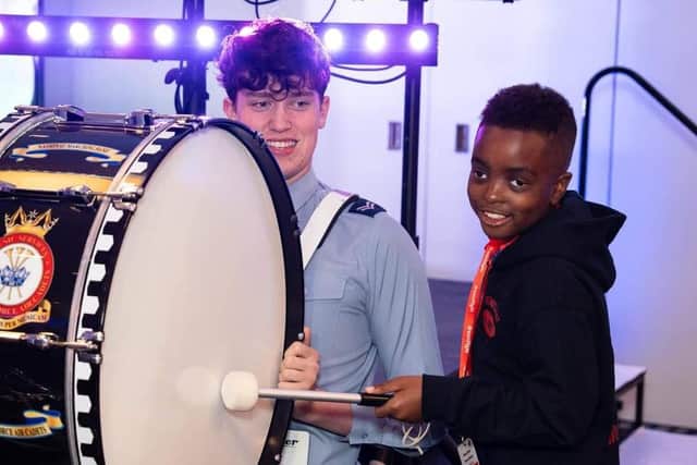 One of Dreamflight's youngsters beats Cpl Thomas Gibbons' bass drum. Photo: Stephen Hullott