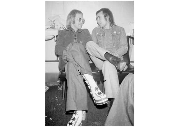 "Looking every inch a 'star' from the boots upwards" The Standard wrote in 1973. Elton John and Bernie Taupin enjoy a moment's relaxation before taking to the stage.
