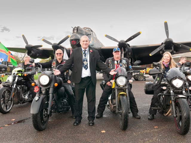 Royal British Legion Chairman John Johnson in front of Lancaster NX611 "Just Jane" at East Kirkby with veterans in the riders' branch.
