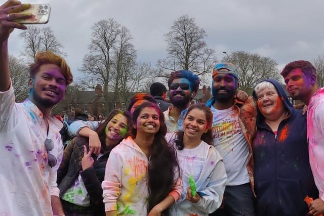 Friends gather for a colourful group selfie at the Holi event in Boston.