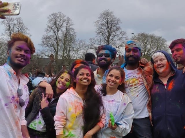 Friends gather for a colourful group selfie at the Holi event in Boston.