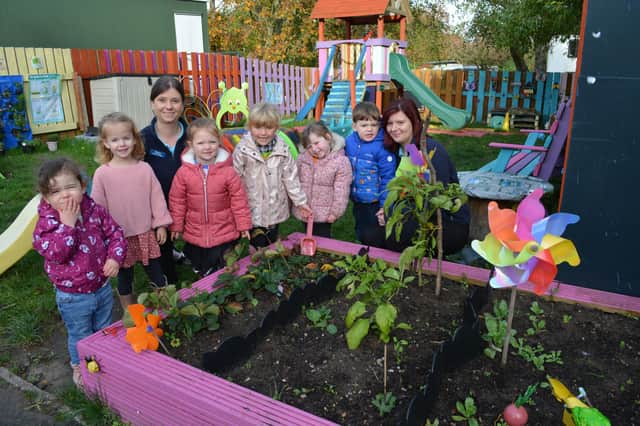 Some of the children at one of the new raised beds, with manager Paige Shackleton, right, and deputy manager Emma Thornalley