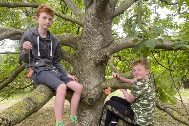 Jack Linder-Arden and Arthur Richmond tie clay decorations to the village tree. All photos by Chris Frear