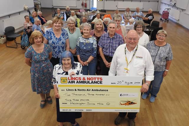 Older Heckington residents raised £2,300 for the Lincs and Notts Air Ambulance by walking a mile a day in June. Pictured are the walkers at the Mix and Mingle Cafe with Pamela Mason at the front with LNAA volunteer Andy Coward.