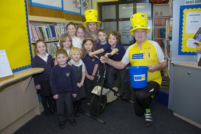 Youngsters from Osbournby Primary School presenting money to Marie Curie Cancer Care. Fundraising efforts including taking turns on a cycling machine to try to cover the distance between London and Paris, inspired by local couple Steve and Jayne Marsh who would be doing the route in real life later that year. Pupils are pictured with Bridgette Burn, headteacher, left, and Steve Marsh.