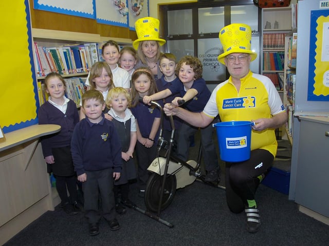 Youngsters from Osbournby Primary School presenting money to Marie Curie Cancer Care. Fundraising efforts including taking turns on a cycling machine to try to cover the distance between London and Paris, inspired by local couple Steve and Jayne Marsh who would be doing the route in real life later that year. Pupils are pictured with Bridgette Burn, headteacher, left, and Steve Marsh.