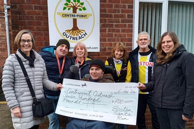 Boston Community Runners volunteers hand over the cheque to representatives from Centrepoint Outreach.