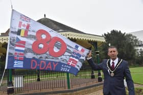 Mayor Coun Adrian Findley in Tower Gardens, Skegness, with the flag celebrating the 80th anniversary of D-Day.
