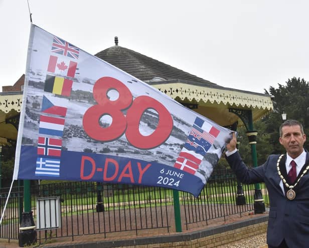 Mayor Coun Adrian Findley in Tower Gardens, Skegness, with the flag celebrating the 80th anniversary of D-Day.