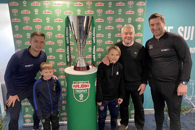 Luke Molyneux (left) and Graeme Lee with Jack, Sam and Chris Warrington next to The Papa John's Trophy at The Suits Direct Stadium.