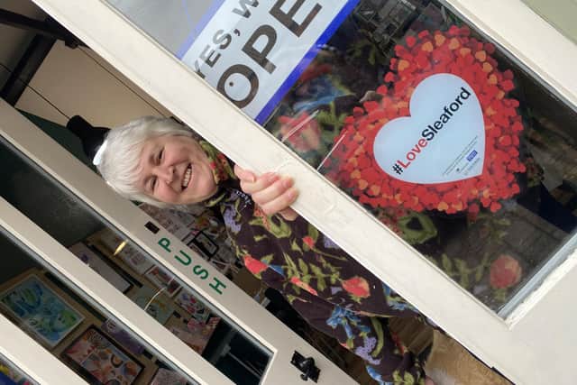 Ruth Burrows at her Art Shop and Studio in Navigation Yard, sporting one of the #LoveSleaford promotional posters.