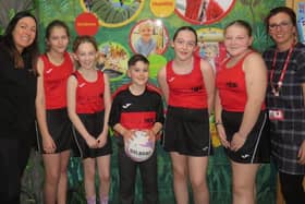 Vicky Morris (left) sponsor and owner of EmpowHer and Emily Smith (teacher) with Church Lane School's netball team and their new kit. Photo supplied