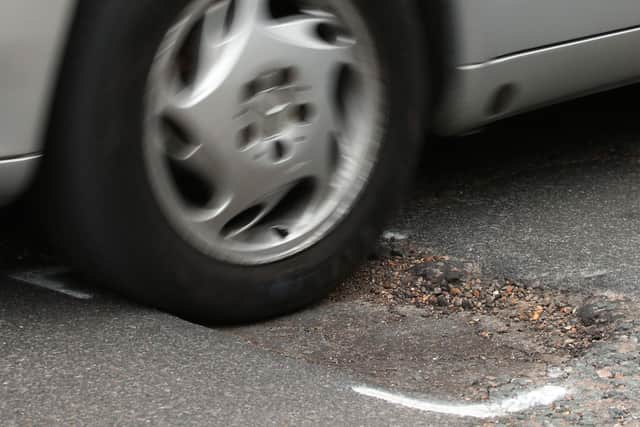 File photo dated 11/05/18 of a car hitting a pothole on a road. Drivers are suffering from a surge in pothole-related breakdowns, new figures from the RAC suggest.