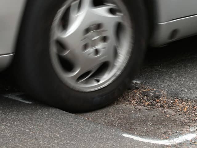 File photo dated 11/05/18 of a car hitting a pothole on a road. Drivers are suffering from a surge in pothole-related breakdowns, new figures from the RAC suggest.