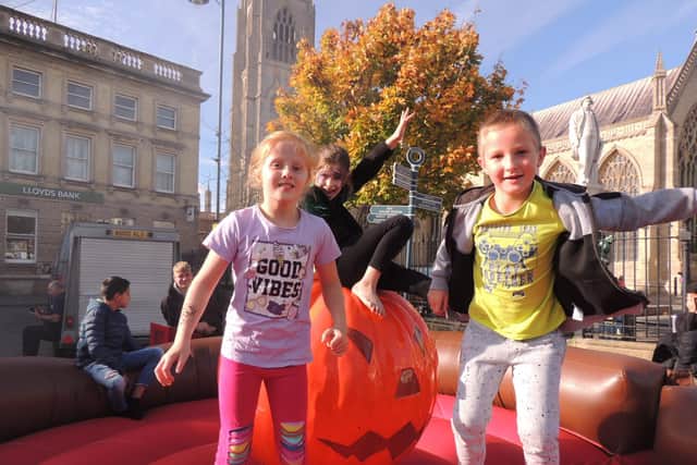 From left - Erica Bajornaite, eight, Tiana Santos-Carr, 10, and Lukas Drabuntas, six, have a bounce on the pumpkin rodeo.