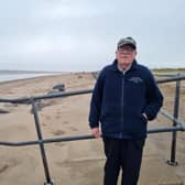Flood warden Coun Malcom Gabbitas by rock sea defences in Skegness that are covered with sand.