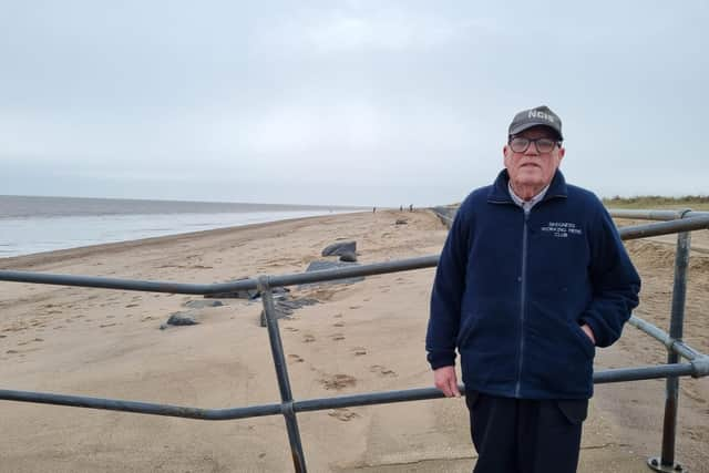 Flood warden Coun Malcom Gabbitas by rock sea defences in Skegness that are covered with sand.