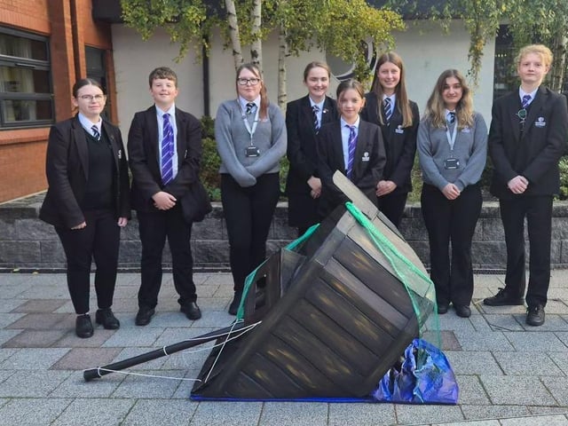 Some of the students with the 'Silent Waters' sculpture - showing a sinking fishing trawler during WWII.