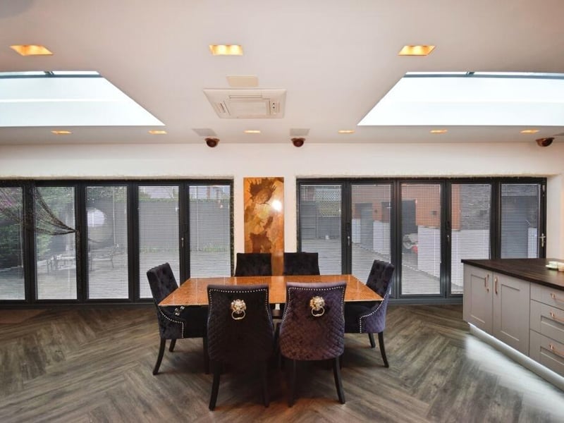 The dining area with two sets of bi-folding doors behind it.