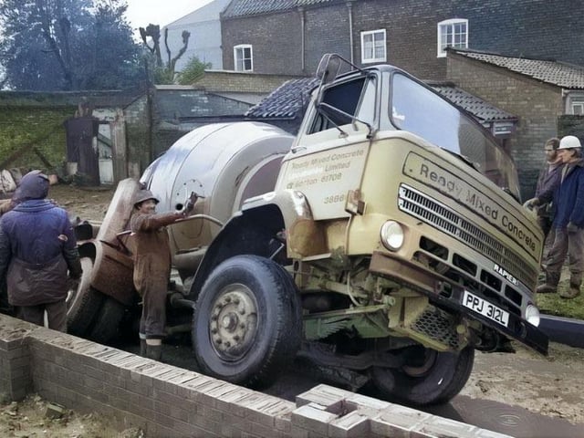 A cement truck encounters difficulty in February 1977 as part of the build.