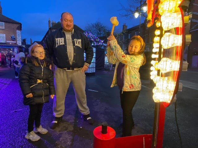 Mr Ochnio watches his daughters test their strength on the fairground striker.