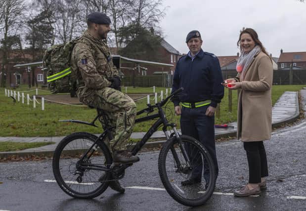 General Manager Jessica De Ruyter and Sergeant Daz Pollard hand bicycle lights to RAF Coningsby personnel. Photo: © UK MOD Crown Copyright 2023