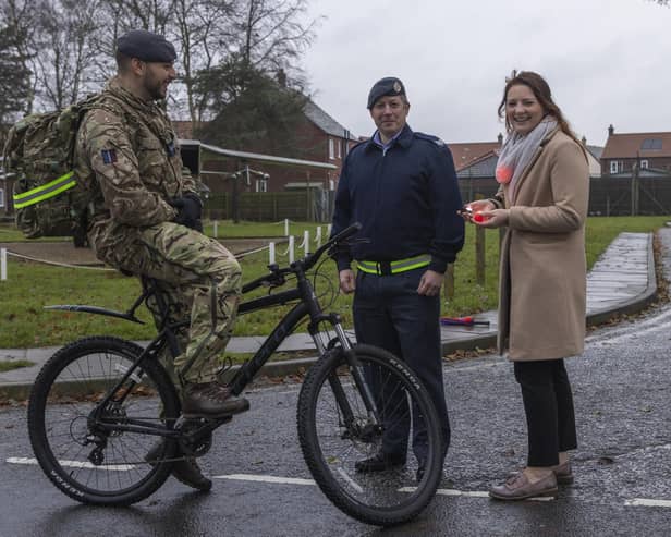 General Manager Jessica De Ruyter and Sergeant Daz Pollard hand bicycle lights to RAF Coningsby personnel. Photo: © UK MOD Crown Copyright 2023
