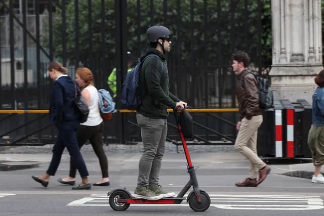 A person riding an electric scooter in Westminster, London.