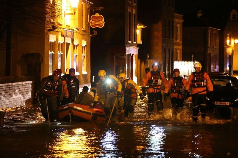 A rescue team pulls a boat with an evacuee on board through flood water in The High Street  (Photo by Peter Macdiarmid/Getty Images)