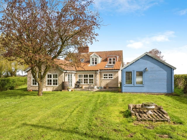 The rear of the home, with log cabin on the right.