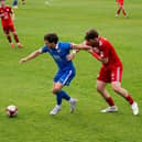 Declan Howe, Trinity's leading marksman holds off Ashton United's experienced Player/ Coach Sean Newton.