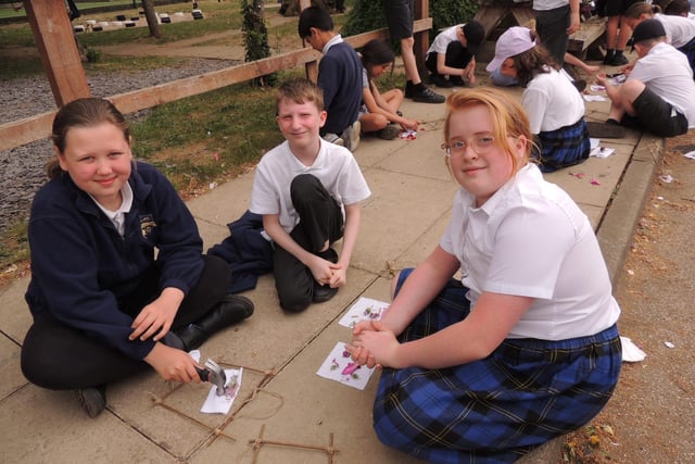 Year 5 pupils hammer flowers into fabric on a willow frame in an artist technique called Hapa Zome. L-R Freya, Bailey and Maisie. Photo: AH