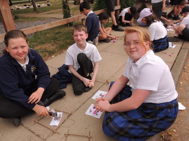 Year 5 pupils hammer flowers into fabric on a willow frame in an artist technique called Hapa Zome. L-R Freya, Bailey and Maisie. Photo: AH