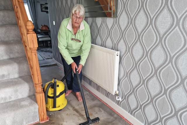 Jean Hart mopping up after her home was flooded for the second time.