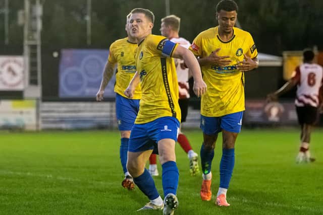 Lewis Butroid celebrates a Trinity brace at Ashton. Photo by Ben Page.