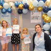 Some of the youngsters collecting their Summer Reading Challenge prizes. From left - Lola Hymers, aged seven, Freya Hymers, nine, Ella Parker, aged three and Sleaford Library Manager Charlotte Harris.