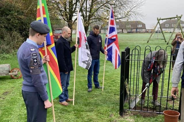 Daphne Norridge plants Dorrington’s new oak tree watched by the three flag bearers and people from the village. Photo: Julia Newton