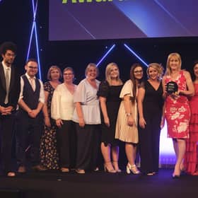 Executive headteacher Nicky Donley (holding the award) and staff collecting the award on behalf of the whole school, pictured with host Richard Ayoade.