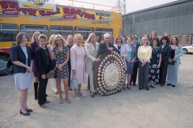 The players' and management staff's wives and girlfriends, alongside the Dr Martens League Premier Division Shield.