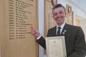 RNLI volunteer Trevor Holland points to the name of his father, who was also a Honorary Citizen in Skegness.