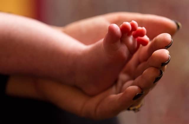 Undated file photo of a mother holding the feet of a new baby. New parents are facing an "accumulation of adversity" after 18 months of Coronavirus restrictions, a cross-party group of MPs has heard. Despite the vaccine rollout and the lockdowns lifting, the Covid-19 pandemic "continues to have a significant impact" on new parents' access to support services and childcare availability, a new report by the Petitions Committee suggests. Issue date: Thursday October 7, 2021.
