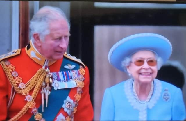 Her Majesty beams with joy as she watches the flypast next to  Prince Charles on the balcony.