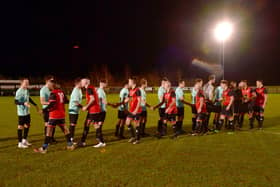 A handshake before kick off. Fire Service (red) v RAF Red Arrows (blue).